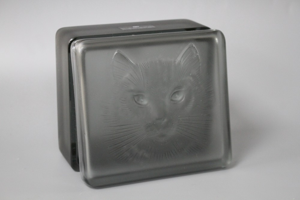 A modern Lalique smoky green tinted glass box, decorated with a cats head, 11 x 9.5cm, height 5cm, with original box